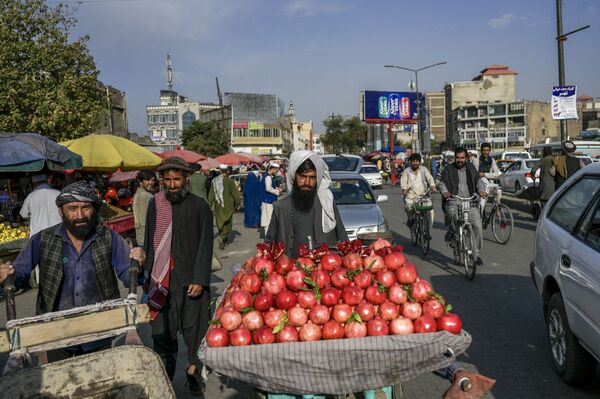In this picture taken on 22 September 2021, a pomegranate seller tries to attract customers in a market area in Kabul. - Sputnik International