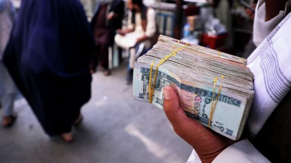 A person holds a bundle of Afghan afghani banknotes at a money exchange market, following banks and markets reopening after the Taliban took over in Kabul, Afghanistan, September 4, 2021.  - Sputnik International