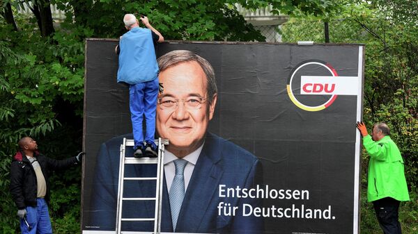 Workers remove an election campaign poster showing Armin Laschet, candidate for Chancellor of Germany's Christian Democratic Union party CDU, the day after the German general elections, in Bad Segeberg near Hamburg, Germany, September 27, 2021 - Sputnik International