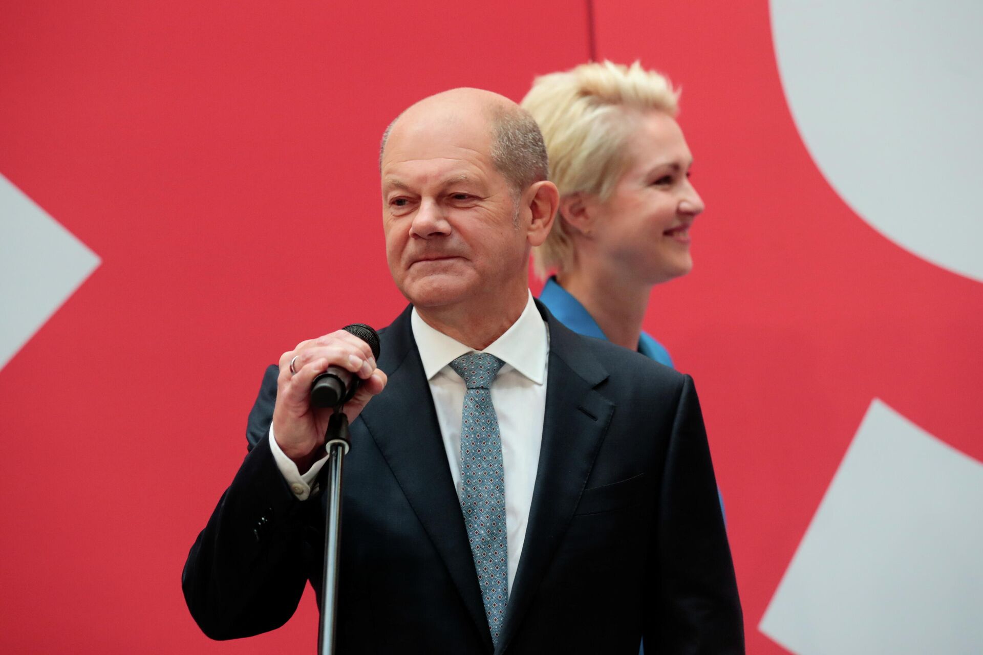 Social Democratic Party (SPD) leader and top candidate for chancellor Olaf Scholz holds a microphone as Mecklenburg-Western Pomerania state Prime Minister Manuela Schwesig walks behind him, one day after the general elections in Berlin, Germany - Sputnik International, 1920, 27.09.2021
