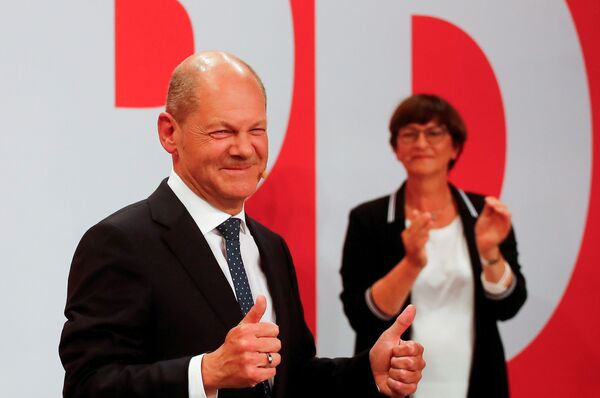 Social Democratic Party (SPD) leader and top candidate for chancellor Olaf Scholz and party co-leader Saskia Esken react after first exit polls for the general elections in Berlin, Germany, 26 September 2021.  - Sputnik International