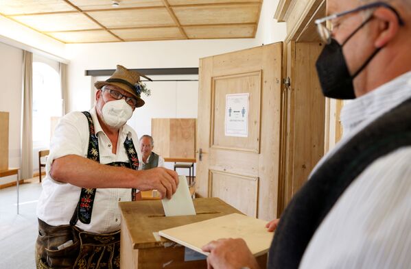 A man wearing a traditional Bavarian costume casts his vote during the general elections in Benediktbeuern, Germany, 26 September 2021.  - Sputnik International