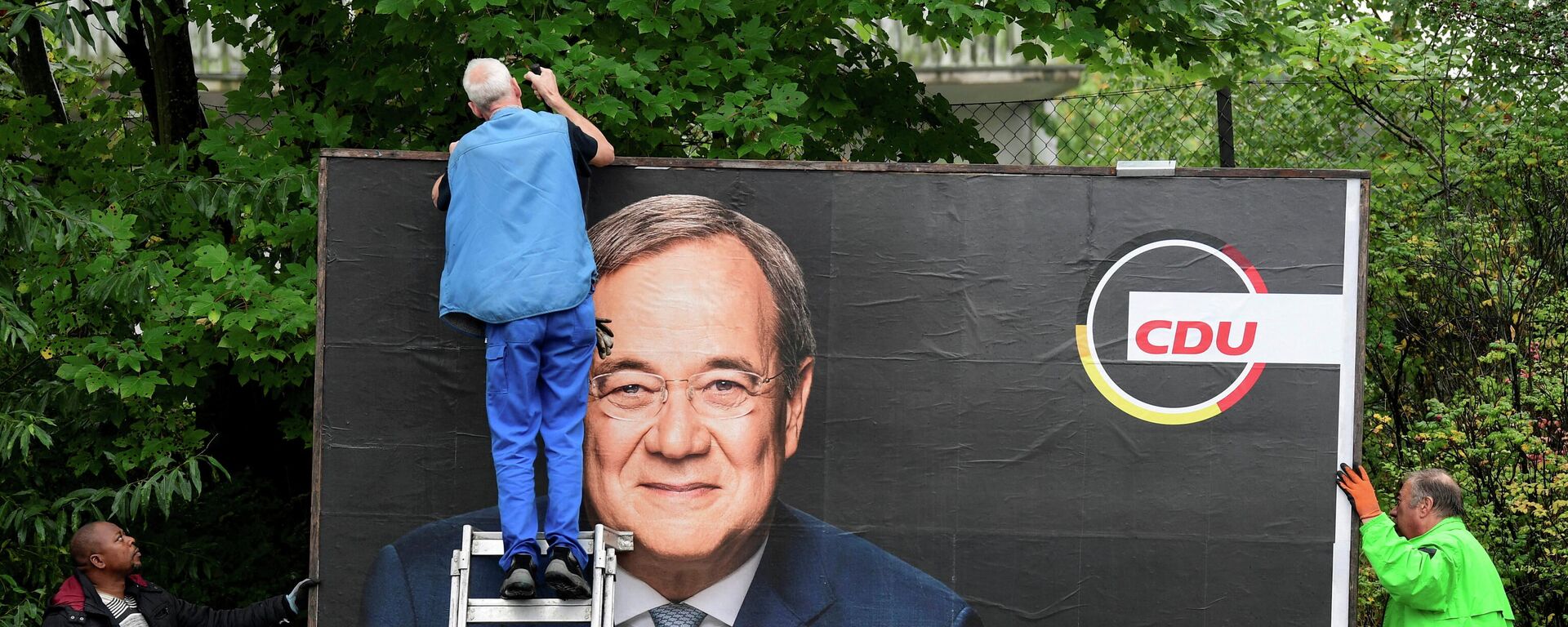 Workers remove an election campaign poster showing Armin Laschet, candidate for Chancellor of Germany's Christian Democratic Union party CDU, the day after the German general elections, in Bad Segeberg near Hamburg, Germany, September 27, 2021 - Sputnik International, 1920, 27.09.2021