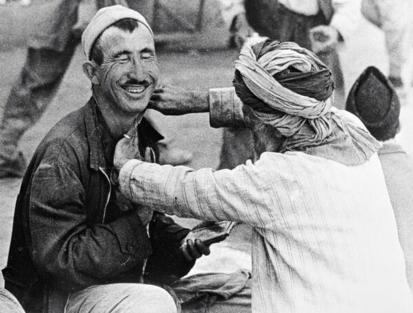 A street barber shaves a Kabul resident. - Sputnik International