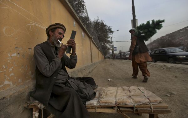 An Afghan roadside barber trims his own beard while waiting for customers in Kabul, 28 October 2010. - Sputnik International