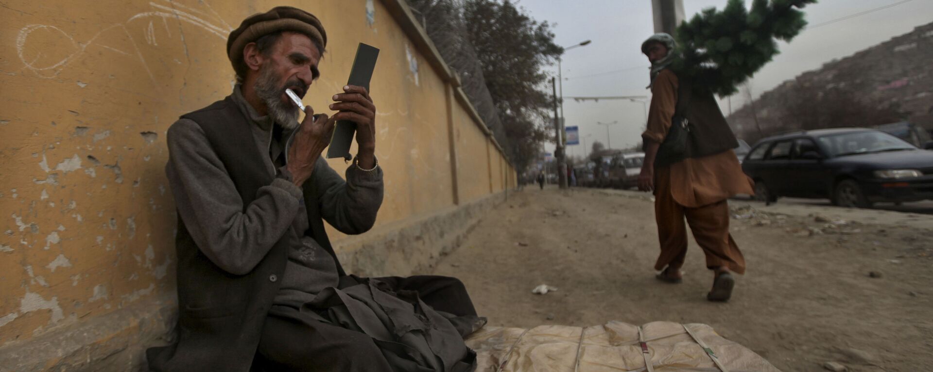 Придорожный парикмахер стрижет себе бороду, ожидая клиентов, Кабул, 2010 год - Sputnik International, 1920, 21.11.2021
