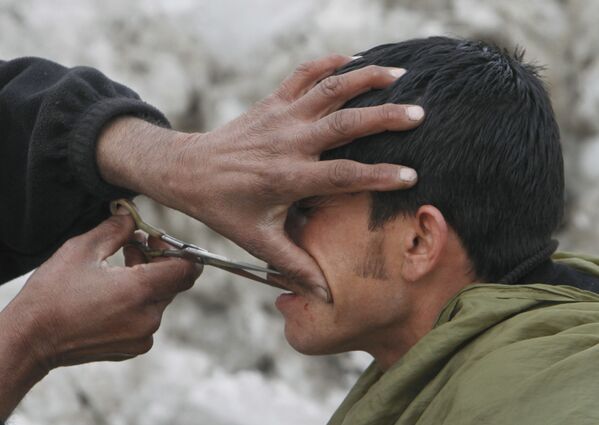 An Afghan barber, trims the moustache of a man in Kabul, 9 February 2012.  - Sputnik International