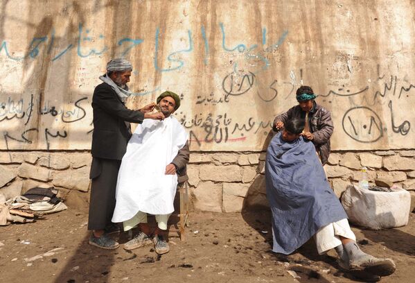Afghan men sit on chairs as they have their hair cut in Herat, 19 February 2012.  - Sputnik International