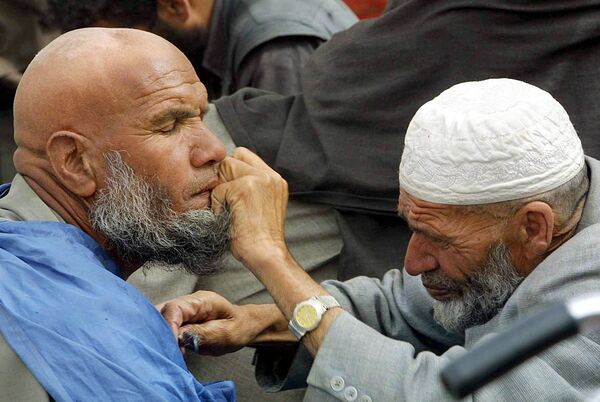 A street barber trims a client&#x27;s beard in Kabul, 5 April 2002.  - Sputnik International