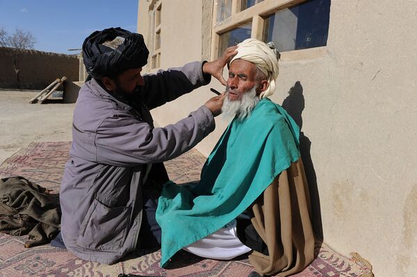 An Afghan barber cuts a man&#x27;s beard in Bangi village, Andar district in Ghazni province, 6 January 2011.  - Sputnik International