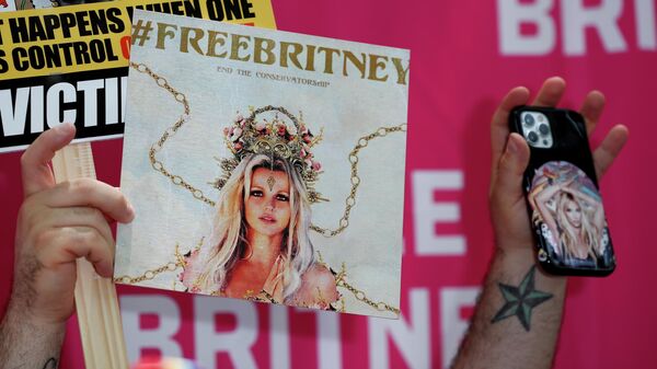 A phone and placards are held during a protest in support of pop star Britney Spears on the day of a conservatorship case hearing at Stanley Mosk Courthouse in Los Angeles, California, US, July 14, 2021 - Sputnik International