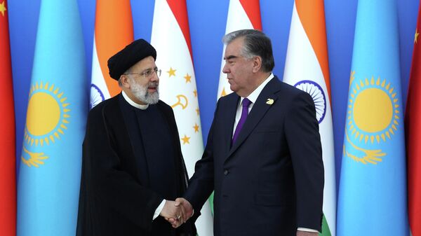 Tajik President Emomali Rakhmon shakes hands with Iranian President Ebrahim Raisi during the Shanghai Cooperation Organization (SCO) summit in Dushanbe, Tajikistan September 17, 2021. - Sputnik International