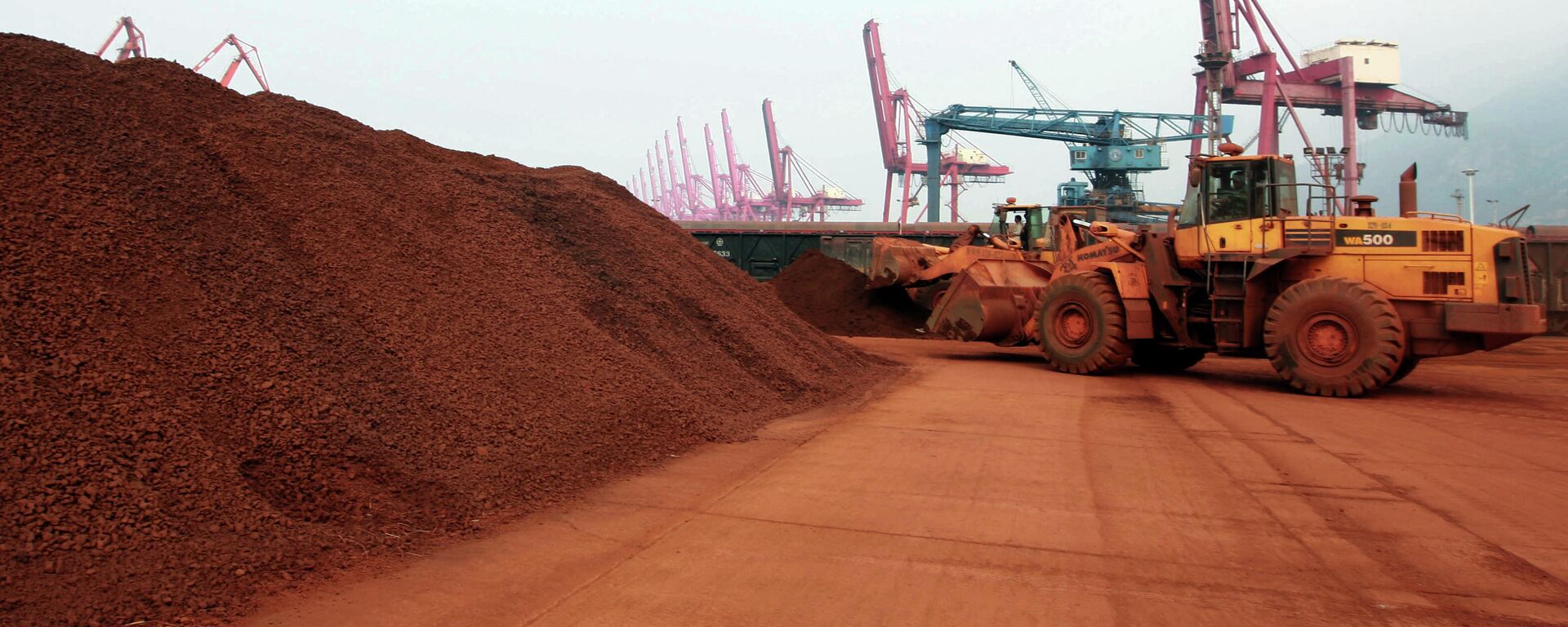 In a picture taken on September 5, 2010 a man driving a front loader shifts soil containing rare earth minerals to be loaded at a port in Lianyungang, east China's Jiangsu province, for export to Japan.  China's restrictions on exports of rare earths are aimed at maximising profit, strengthening its homegrown high-tech companies and forcing other nations to help sustain global supply, experts say. China last year produced 97 percent of the global supply of rare earths -- a group of 17 elements used in high-tech products ranging from flat-screen televisions to iPods to hybrid cars -- but is home to just a third of reserves.  CHINA OUT   AFP PHOTO (Photo by STR / AFP) - Sputnik International, 1920, 01.10.2021