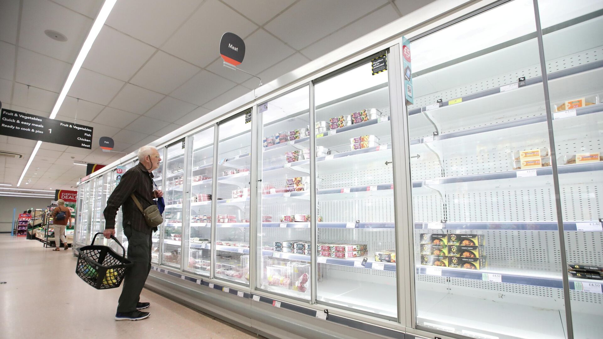 FILE PHOTO: A shopper looks at produce and empty shelves of the meat aisle in Co-Op supermarket, Harpenden - Sputnik International, 1920, 04.10.2021