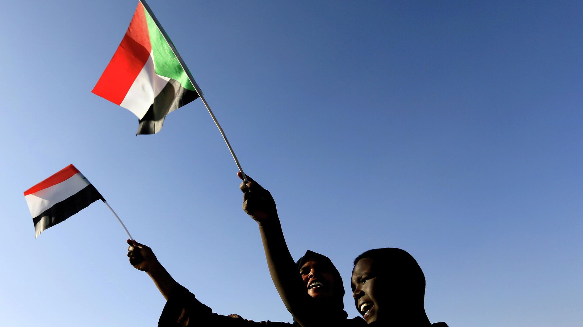 Sudanese wave their national flag as they gather at freedom square during the first anniversary of the start of the uprising that toppled long-time ruler Omar al-Bashir, in Khartoum, Sudan December 19, 2019.  - Sputnik International, 1920, 25.10.2021