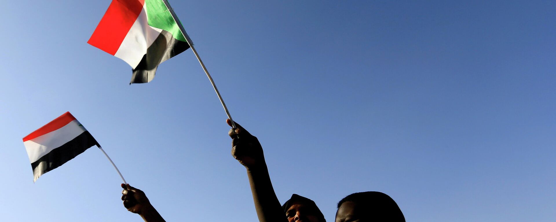 Sudanese wave their national flag as they gather at freedom square during the first anniversary of the start of the uprising that toppled long-time ruler Omar al-Bashir, in Khartoum, Sudan December 19, 2019.  - Sputnik International, 1920, 30.10.2021
