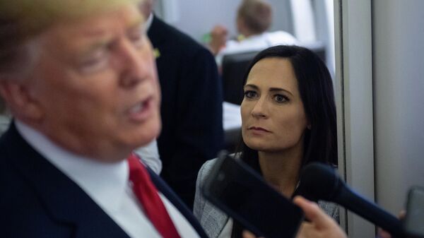 In this file photo former White House Press Secretary Stephanie Grisham listens as US President Donald Trump speaks to the media aboard Air Force One while flying between El Paso, Texas and Joint Base Andrews in Maryland, August 7, 2019. - An aide dubbed the Music Man was tasked with playing calming tunes for Donald Trump when he went into rages, according to a scandal-filled book by a former press secretary.Stephanie Grisham, notorious for not giving a single televised press conference while serving as Trump's chief spokeswoman, writes in I'll Take Your Questions Now that her boss went into terrifying rants.The former president and his wife Melania have vociferously condemned the book, excerpts of which appeared on September 28, 2021 in The New York Times and Washington Post. - Sputnik International