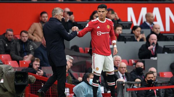 Manchester United's Norwegian manager Ole Gunnar Solskjaer (L) shakes hands with Manchester United's Portuguese striker Cristiano Ronaldo as he comes off the substitutes bench  during the English Premier League football match between Manchester United and Everton at Old Trafford in Manchester, north west England, on October 2, 2021. - Sputnik International