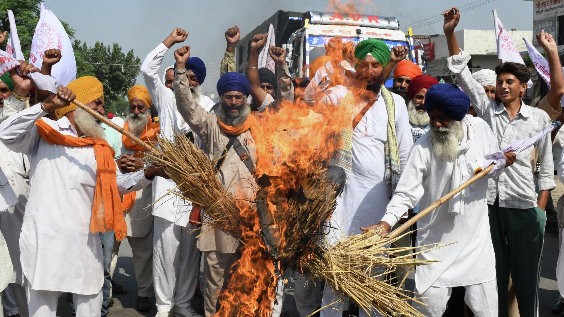 Farmers shout slogans as they burn an effigy of India's Prime Minister Narendra Modi and Uttar Pradesh state Chief Minister Yogi Adityanath during a protest on the outskirts of Amritsar on October 6, 2021, days after 9 people died in violent clashes during a farmers protest in Lakhimpur Kheri district in Utta Pradesh - Sputnik International, 1920, 08.10.2021