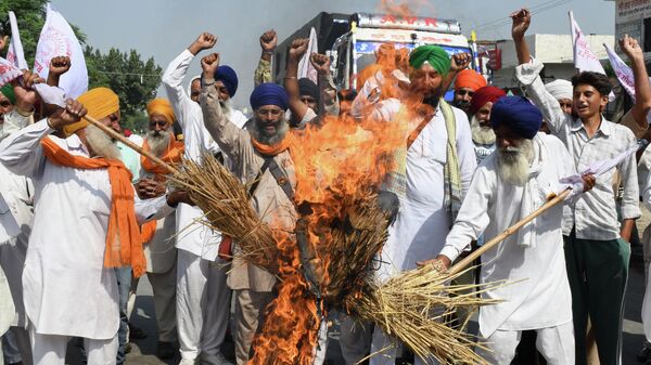 Farmers shout slogans as they burn an effigy of India's Prime Minister Narendra Modi and Uttar Pradesh state Chief Minister Yogi Adityanath during a protest on the outskirts of Amritsar on October 6, 2021, days after 9 people died in violent clashes during a farmers protest in Lakhimpur Kheri district in Utta Pradesh - Sputnik International