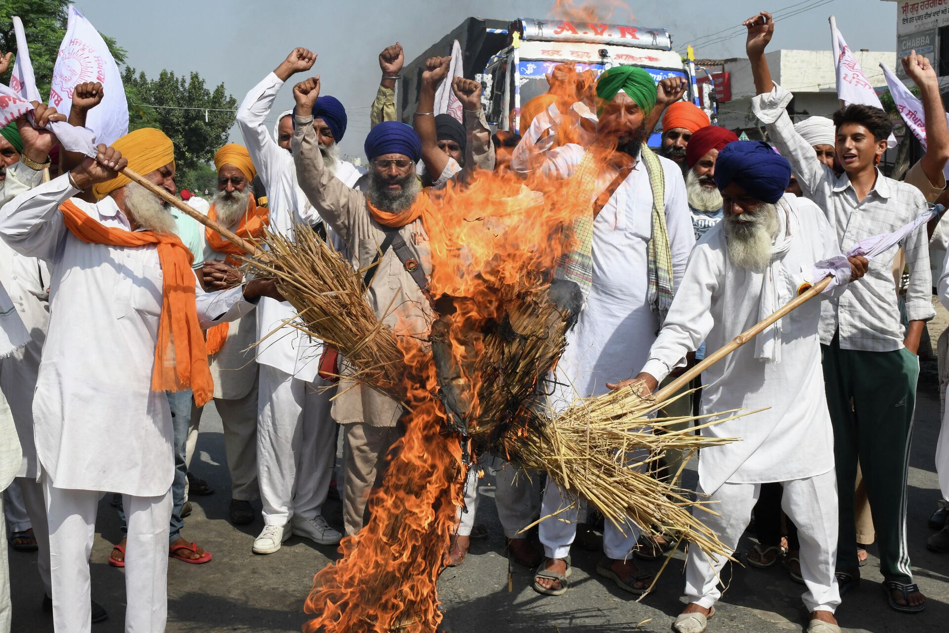 Farmers shout slogans as they burn an effigy of India's Prime Minister Narendra Modi and Uttar Pradesh state Chief Minister Yogi Adityanath during a protest on the outskirts of Amritsar on October 6, 2021, days after 9 people died in violent clashes during a farmers protest in Lakhimpur Kheri district in Utta Pradesh - Sputnik International, 1920, 18.10.2021