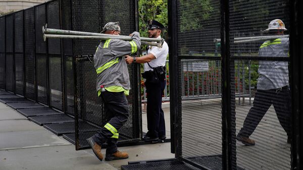 Construction workers walk through a security fence around the Supreme Court in Washington, Friday, Sept. 17, 2021, ahead of a weekend rally planned by allies of Donald Trump that is aimed at supporting the so-called political prisoners of the Jan. 6 insurrection at the U.S. Capitol - Sputnik International