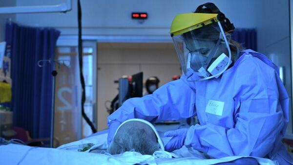 A member of the clinical staff wearing Personal Protective Equipment PPE cares for a patient with coronavirus in the intensive care unit at the Royal Papworth Hospital in Cambridge, England, Tuesday May 5, 2020 - Sputnik International