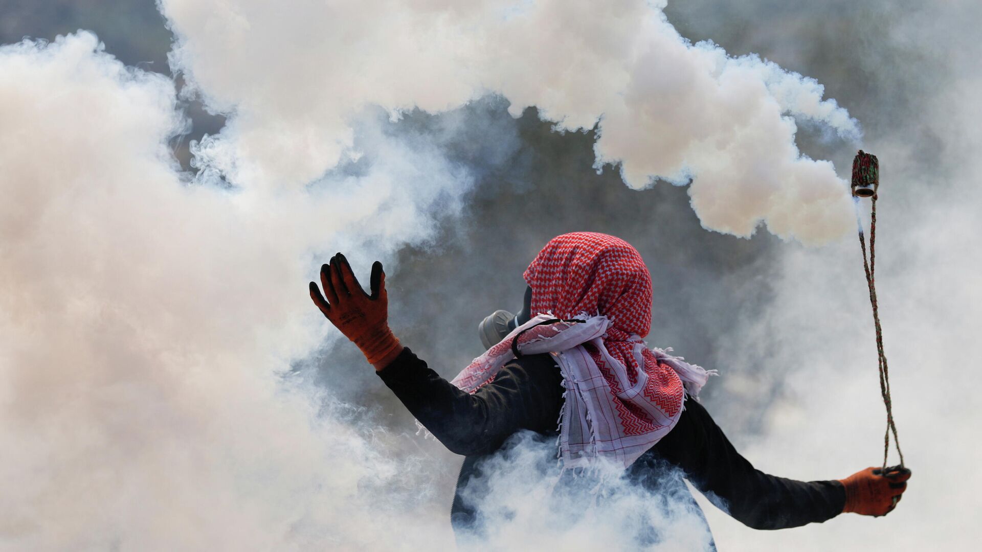 A Palestinian uses a sling as demonstrators clash with Israeli forces during a protest against Israeli settlements, in Beita, in the Israeli-occupied West Bank October 8, 2021. - Sputnik International, 1920, 08.10.2021