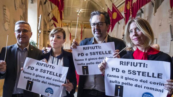 This photo obtained from Italian news agency Ansa on October 6, 2021 shows Fratelli d'Italia party town councillors (From L) Francesco Figliomeni, Rachele Mussolini, Andrea De Priamo and Lavinia Mennuni holding a protest about the town's waste management during a city council meeting in Rome on December 6, 2019. - Sputnik International