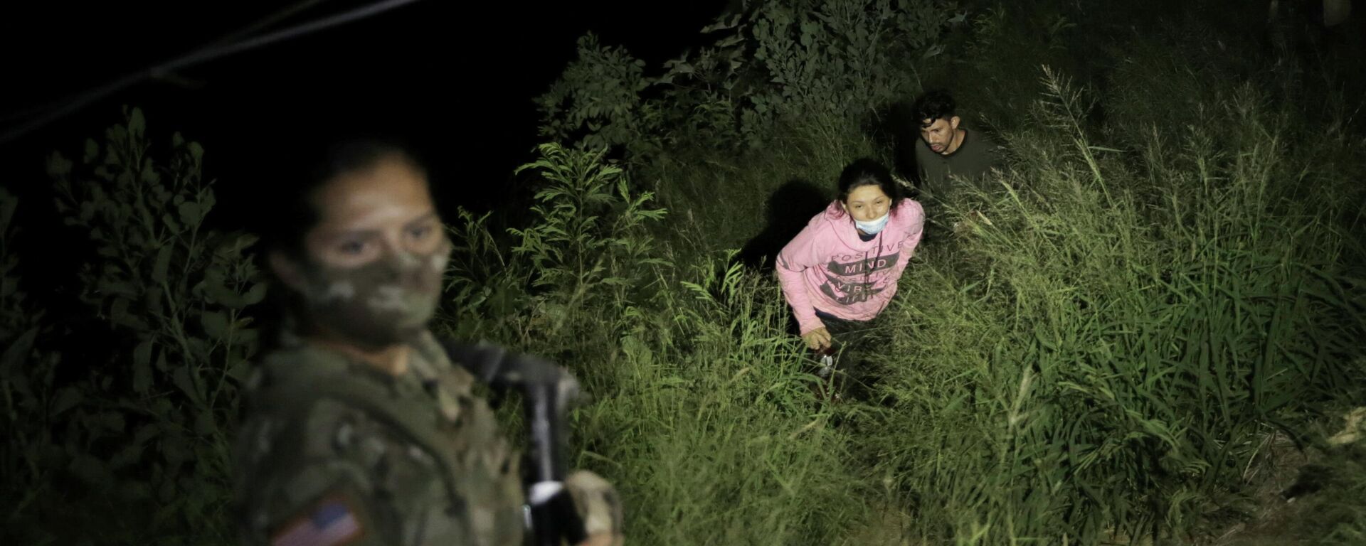 A Texas National Guard member illuminates a path as migrants cross over to the U.S., north of the Roma–Ciudad Miguel Aleman International Bridge, which spans the Rio Grande border with Mexico, in Roma, Texas, U.S. October 1, 2021. Picture taken October 1, 2021 - Sputnik International, 1920, 09.10.2021