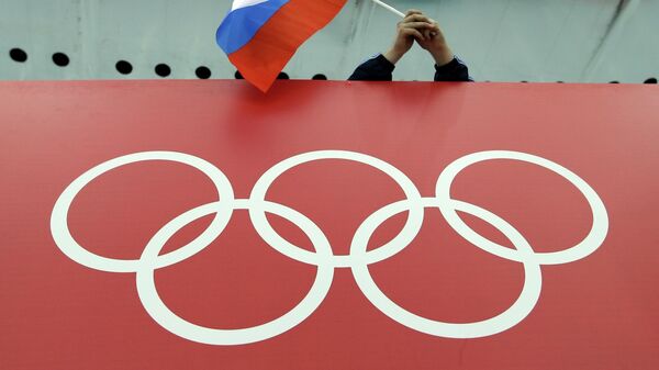 In this Feb. 18, 2014, file photo, a Russian skating fan holds the country's national flag over the Olympic rings before the men's 10,000-meter speedskating race at Adler Arena Skating Center during the Winter Olympics in Sochi, Russia. Formed with good intentions, the World Anti-Doping Agency finds itself at a crossroads as it celebrates its 20th anniversary at a conference this week in Poland. It’s an agency riven with conflicts that have hindered its fight against drugs and exacerbated its 4-year-old struggle in the high-profile case against Russia. - Sputnik International