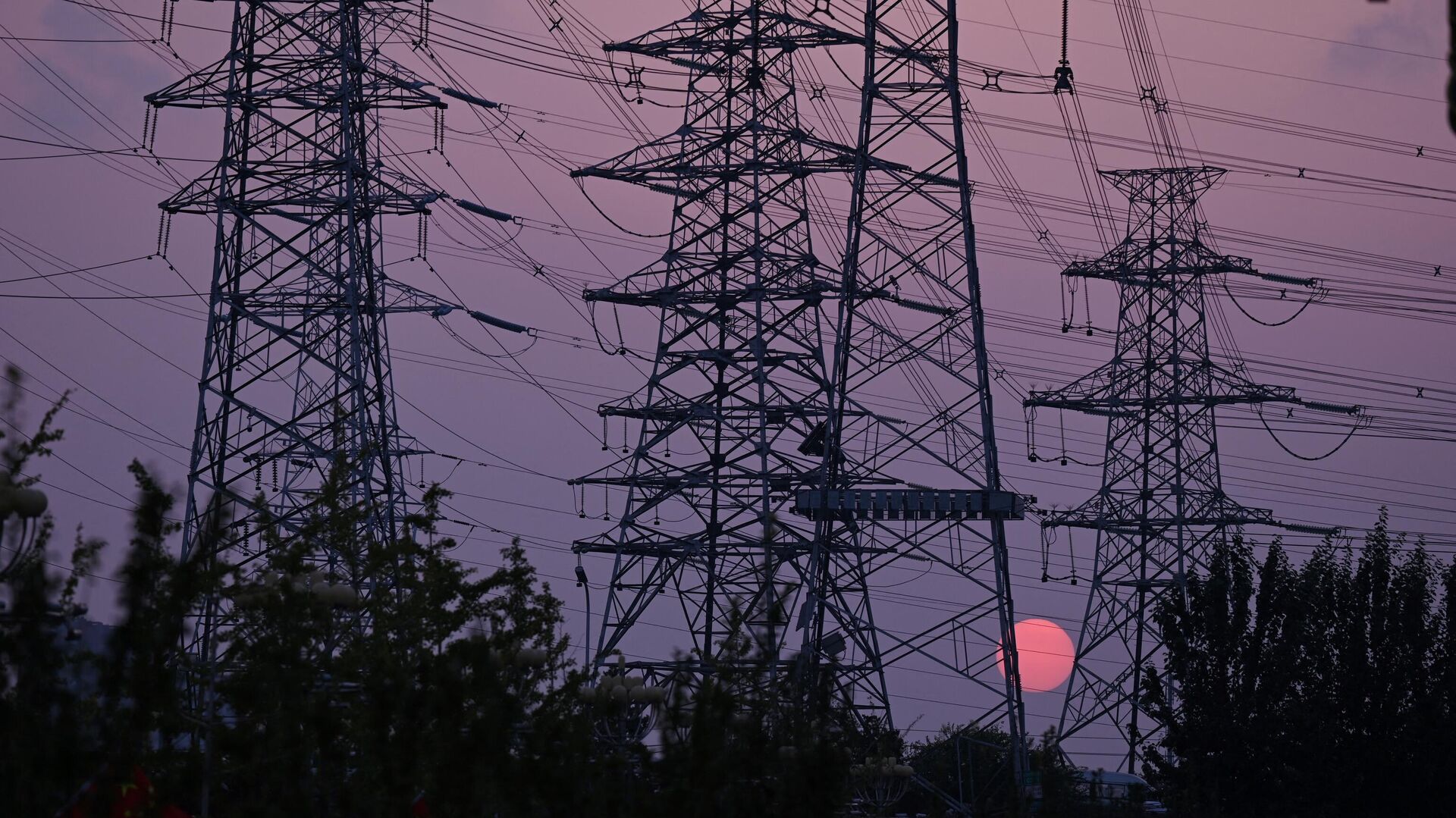 The sun sets behind electricity power pylons in Beijing on September 28, 2021 - Sputnik International, 1920, 10.10.2021