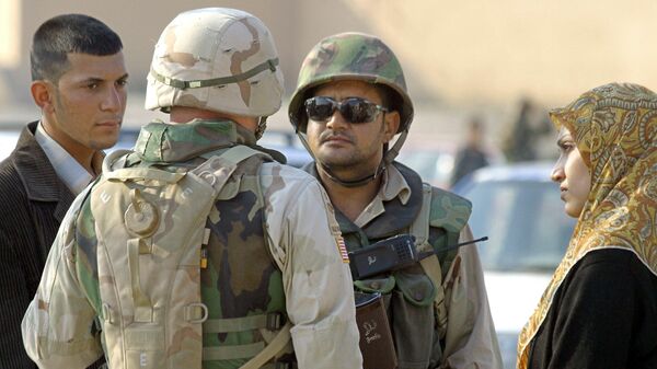 A US soldier speaks with a member of the Iraqi Civil Defense Corps (ICDC) during a monitored vehicle security search of vehicles in the town of Fallujah, 50 kms west of Baghdad, 04 January 2004 - Sputnik International