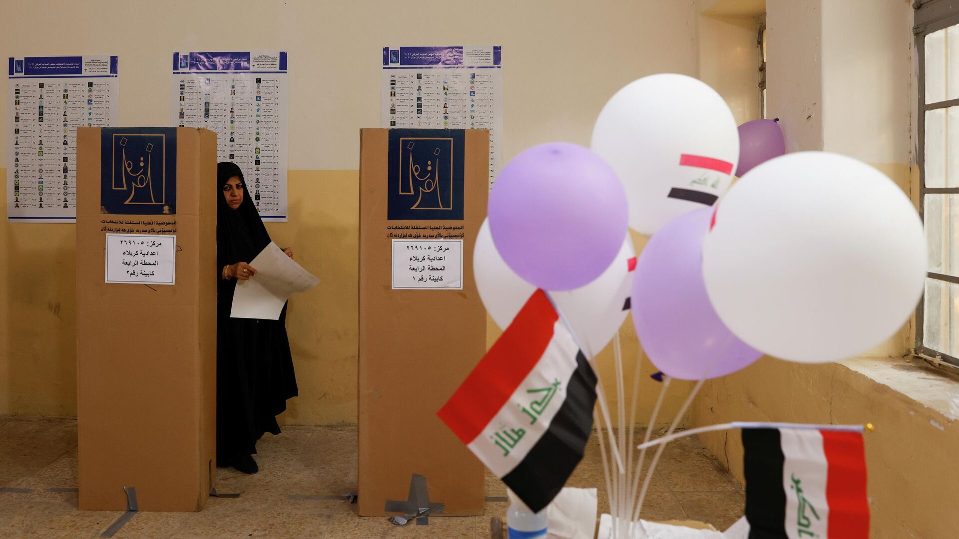 A woman attends voting at a polling station during the parliamentary election, in Kerbala, Iraq, October 10, 2021. - Sputnik International, 1920, 11.10.2021