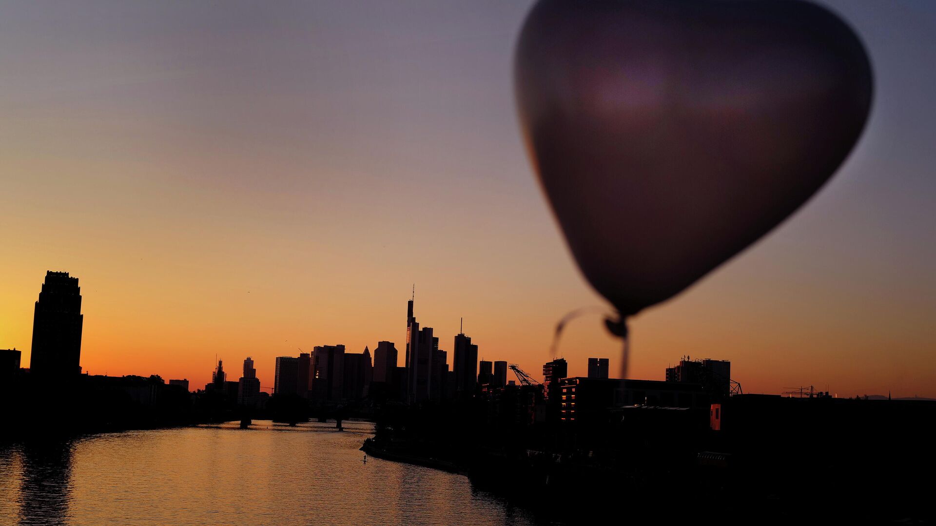 A heart-shaped balloon is seen during sunset in front of the skyline of the banking district in Frankfurt, Germany, October 10, 2021. - Sputnik International, 1920, 11.10.2021