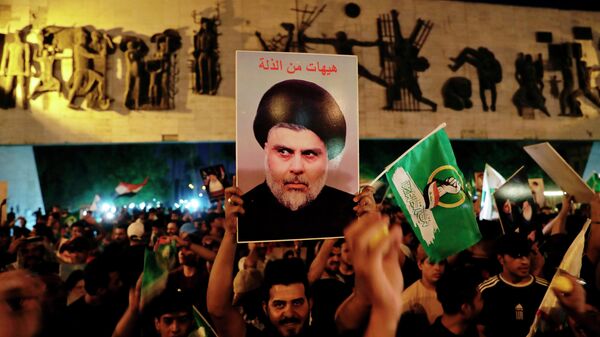 Followers of Shiite cleric Muqtada al-Sadr celebrate holding his posters, after the announcement of the results of the parliamentary elections in Tahrir Square, Baghdad, Iraq, Monday, Oct. 11, 2021. - Sputnik International