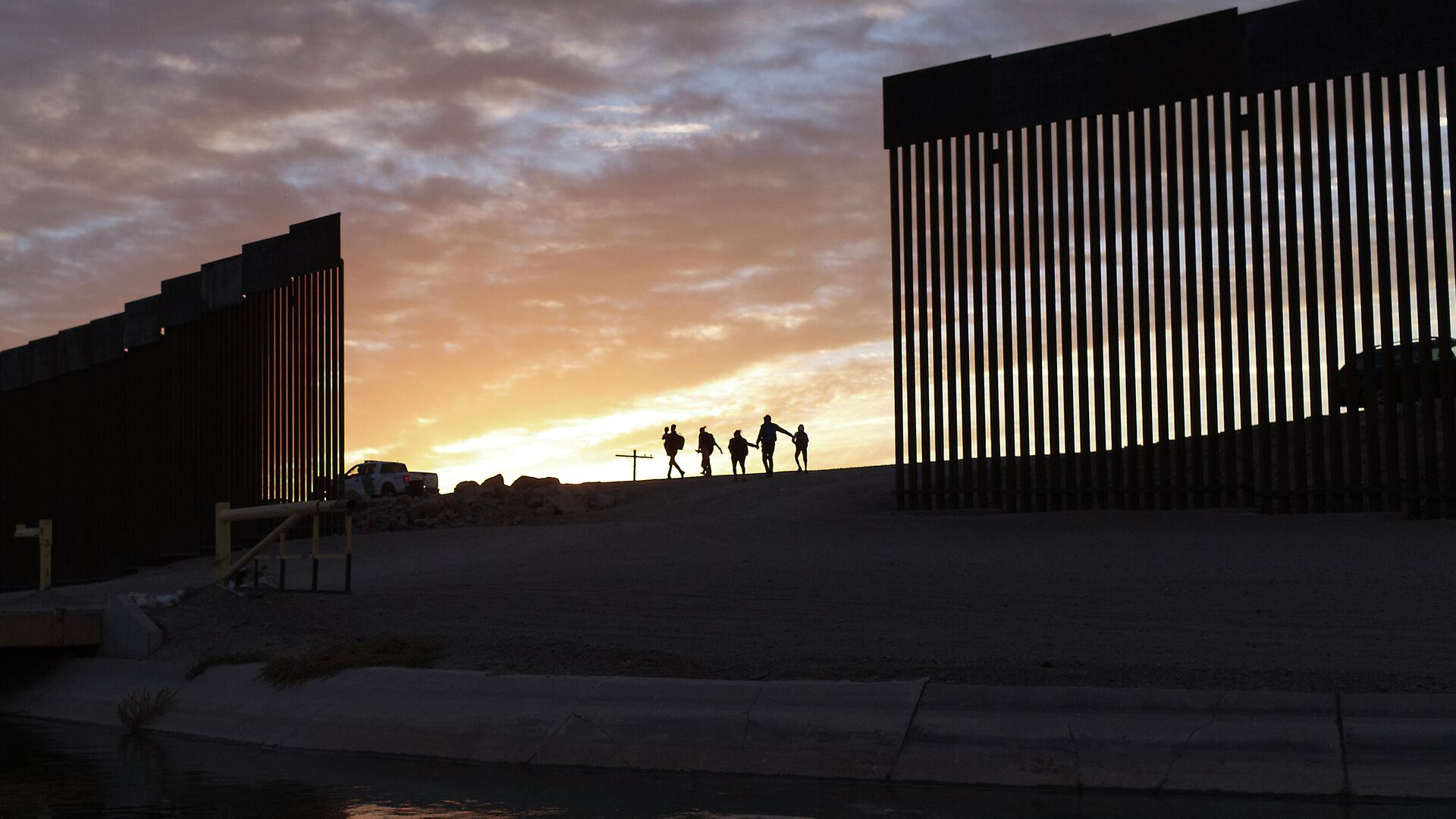In this Thursday, June 10, 2021, file photo, a pair of migrant families from Brazil pass through a gap in the border wall to reach the United States after crossing from Mexico to Yuma, Ariz., to seek asylum. - Sputnik International, 1920, 18.04.2022