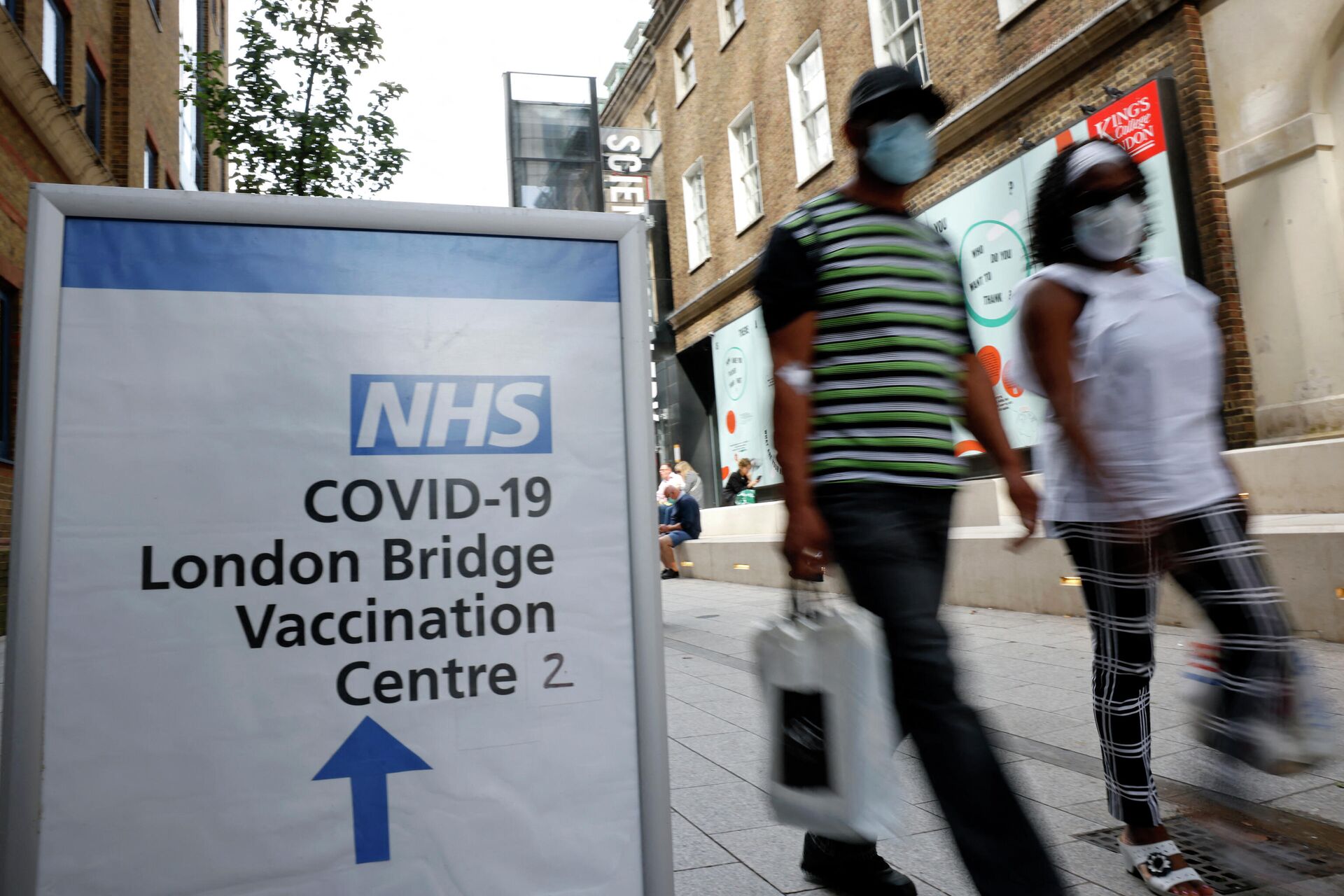 People pass signs indicating the entrance to the London Bridge Vaccination Centre in London on August 9, 2021 - Sputnik International, 1920, 22.10.2021