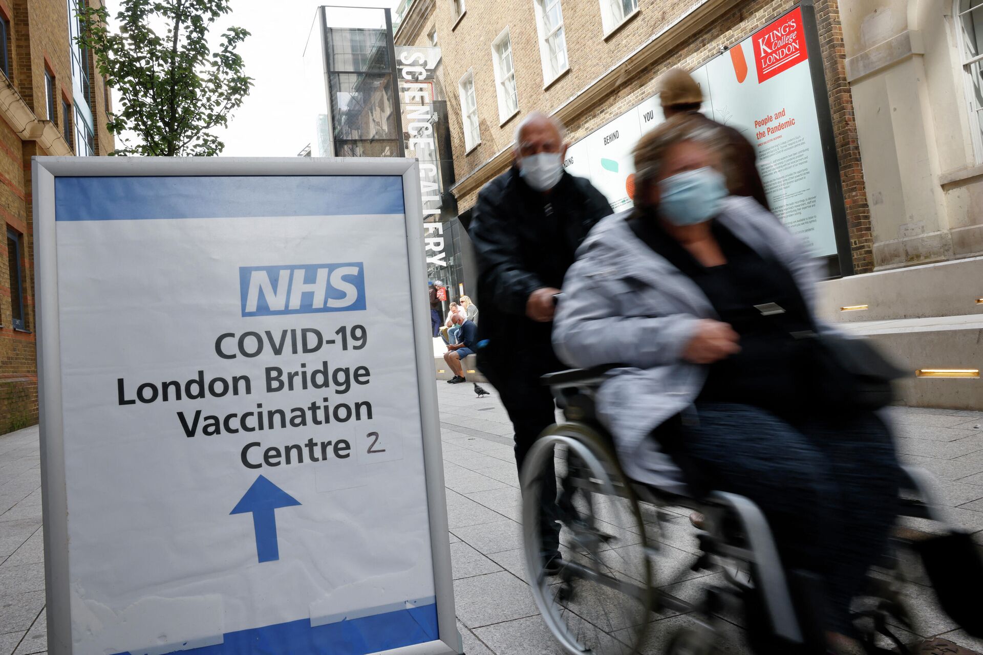 People pass signs indicating the entrance to the London Bridge Vaccination Centre in London on August 9, 2021 - Sputnik International, 1920, 14.10.2021