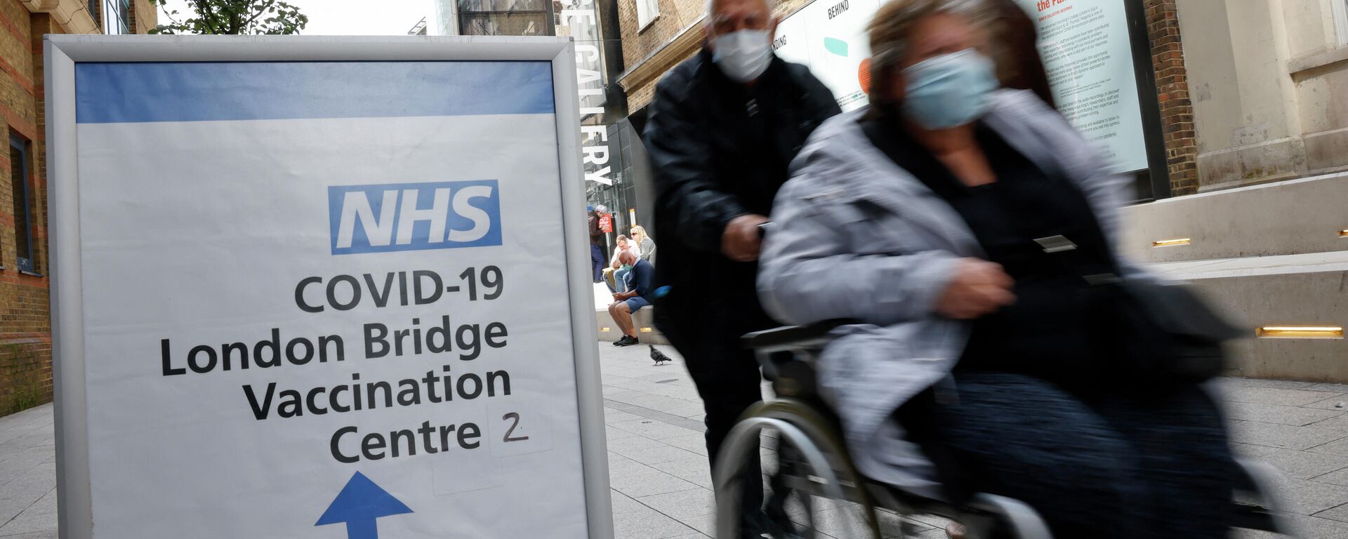 People pass signs indicating the entrance to the London Bridge Vaccination Centre in London on August 9, 2021 - Sputnik International, 1920, 12.10.2021