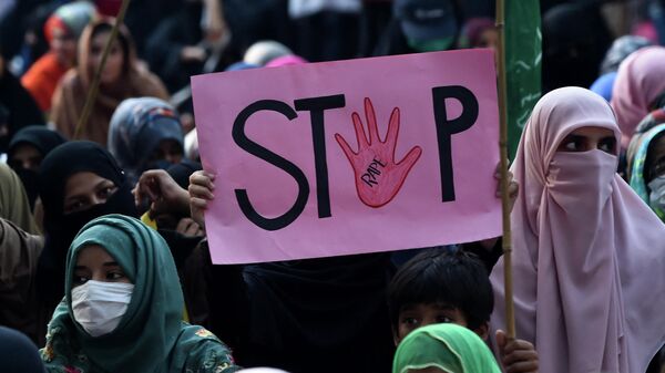A supporter of Pakistani Islamic political party Jamaat-e-Islami (JI) holds a placard reading Stop during a protest against an alleged gang rape of a woman, in Lahore on September 17, 2020.  - Sputnik International