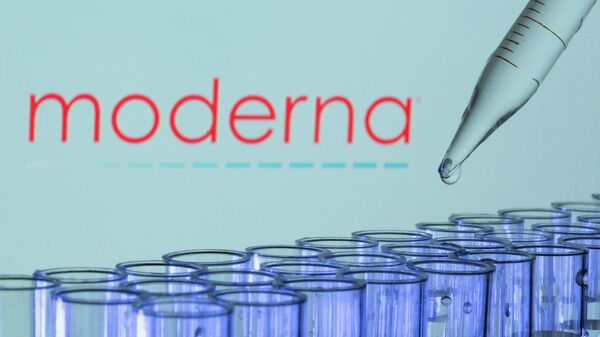 Test tubes are seen in front of a displayed Moderna logo in this illustration - Sputnik International
