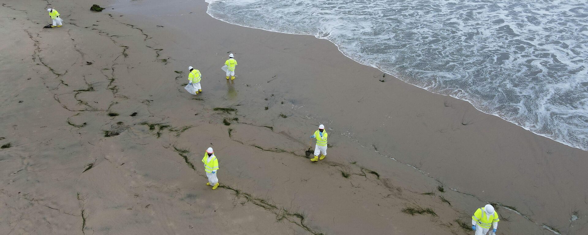 Workers rake up globs of crude oil after more than 3,000 barrels (126,000 gallons) of crude oil leaked from a ruptured pipeline into the Pacific Ocean in Corona Del Mar State Beach, Newport Beach, California, U.S. October 7, 2021. - Sputnik International, 1920, 17.10.2021