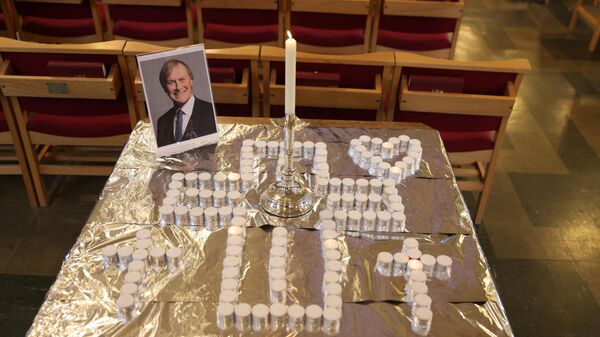 A photograph of British lawmaker David Amess is seen on a table with an arrangement of candles at St Michael's and All Angels Church, Leigh-on-Sea, a district of Southend-on-Sea, southeast England, on October 17, 2021 - Sputnik International