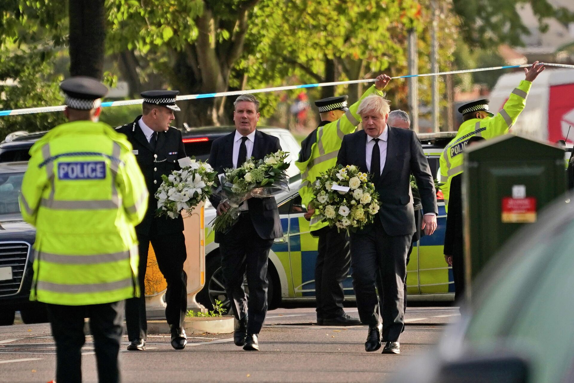 British Prime Minister Boris Johnson, right, and Leader of the Labour Party Sir Keir Starmer, second from right, carry flowers as they arrive at the scene where a member of Parliament was stabbed Friday, in Leigh-on-Sea, Essex, England, Saturday, Oct. 16, 2021 - Sputnik International, 1920, 21.10.2021