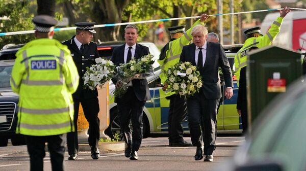 British Prime Minister Boris Johnson, right, and Leader of the Labour Party Sir Keir Starmer, second from right, carry flowers as they arrive at the scene where a member of Parliament was stabbed Friday, in Leigh-on-Sea, Essex, England, Saturday, Oct. 16, 2021 - Sputnik International