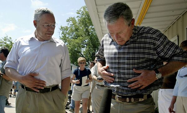 US President George W. Bush, with Secretary of State Colin Powell, responds to a question from the press about his recent weight gain during a stop to talk with the press outside a Crawford, Texas restaurant where the two men had lunch, 6 August 2003. - Sputnik International