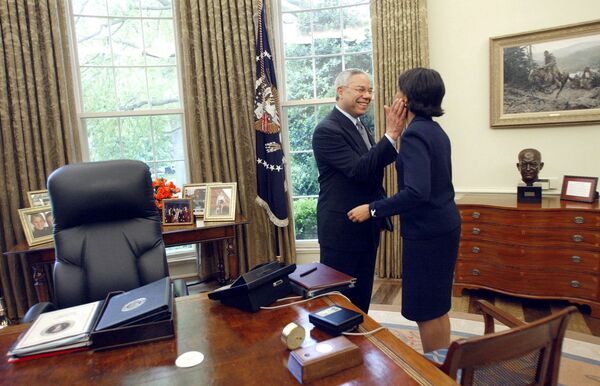 US National Security Adviser Condoleezza Rice receives a pat on the cheek from US Secretary of State Colin Powell in the Oval Office as President George W. Bush was finishing a meeting with Israeli Prime Minister Ariel Sharon on 7 May 2002. - Sputnik International