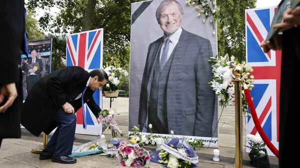 Members of the Anglo-Iranian community and supporters of the National Council of Resistance of Iran (NCRI) attend a memorial service to pay tribute to  slain British lawmaker David Amess in Parliament Square in front of the Houses of Parliament in central London on October 18, 2021 - Sputnik International