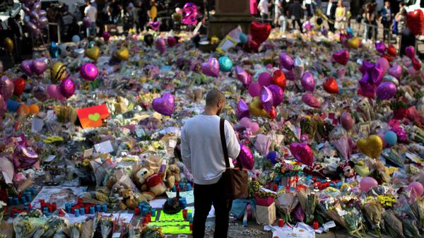 A man stands next to flowers for the victims of Monday's bombing at St Ann's Square in central Manchester, England, Friday, May 26 2017 - Sputnik International